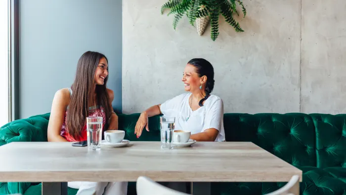 Dos mujeres conversando en una cafetería
