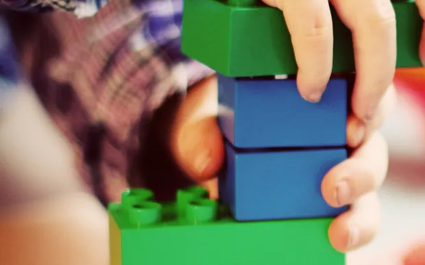Niño jugando con bloques de construcción en terapia infantil